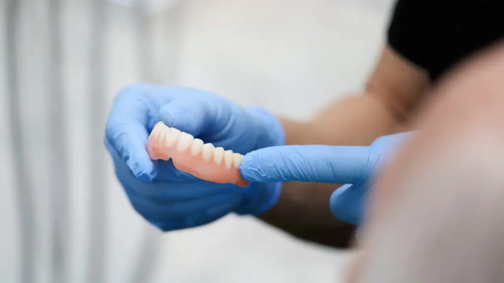 Denturist holding on to a set of full dentures