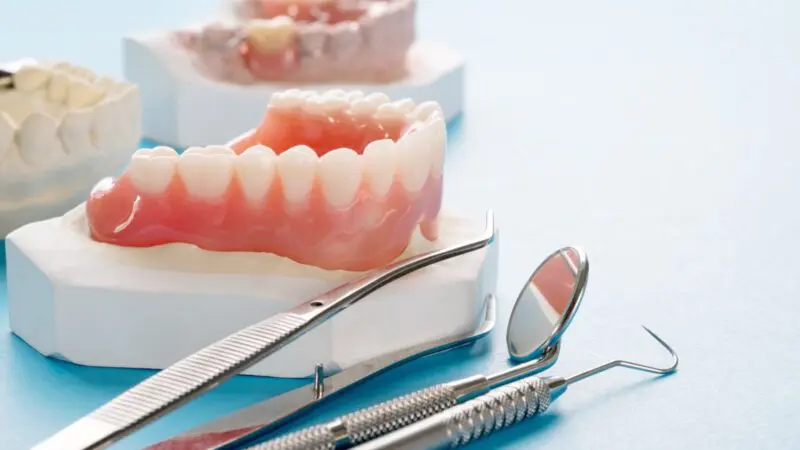 Close up , Complete denture or full denture on blue background.