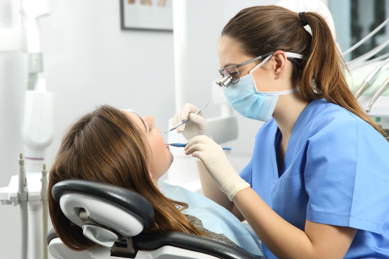 Dental hygienist examining a patient teeth