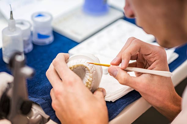 Denturist preparing dentures in a mould