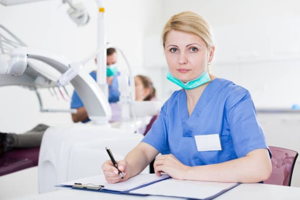 Dental technician taking records during an exam