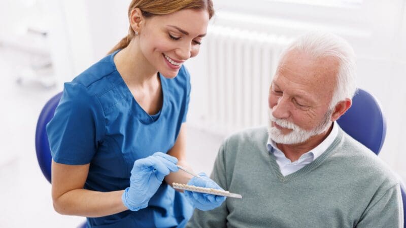 Dentist showing zirconium dental veneers color palette to patient