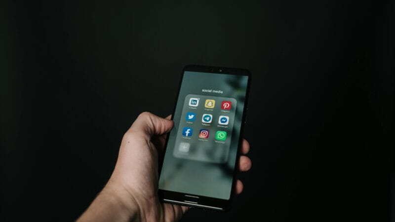 Person using social media apps on smartphone for business marketing