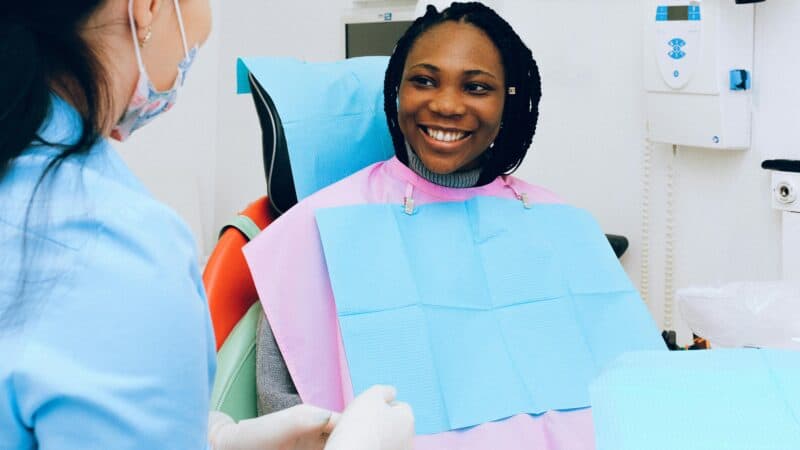 Happy child sitting in dental chair for first dentist visit