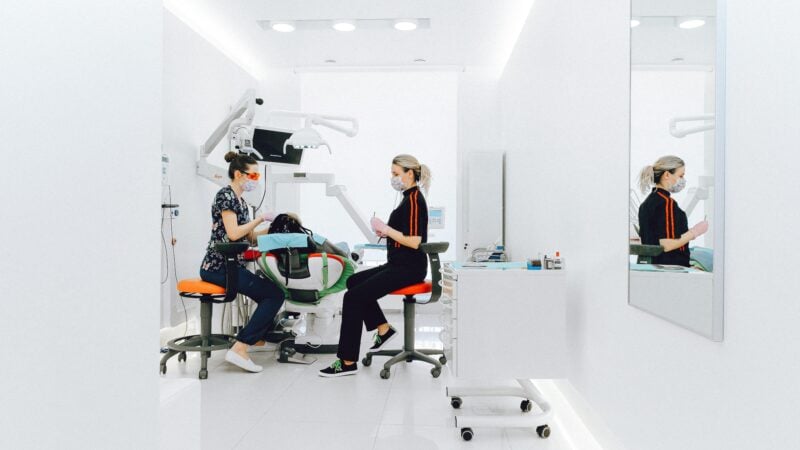 Dentist shaking hands with returning patient at dental clinic